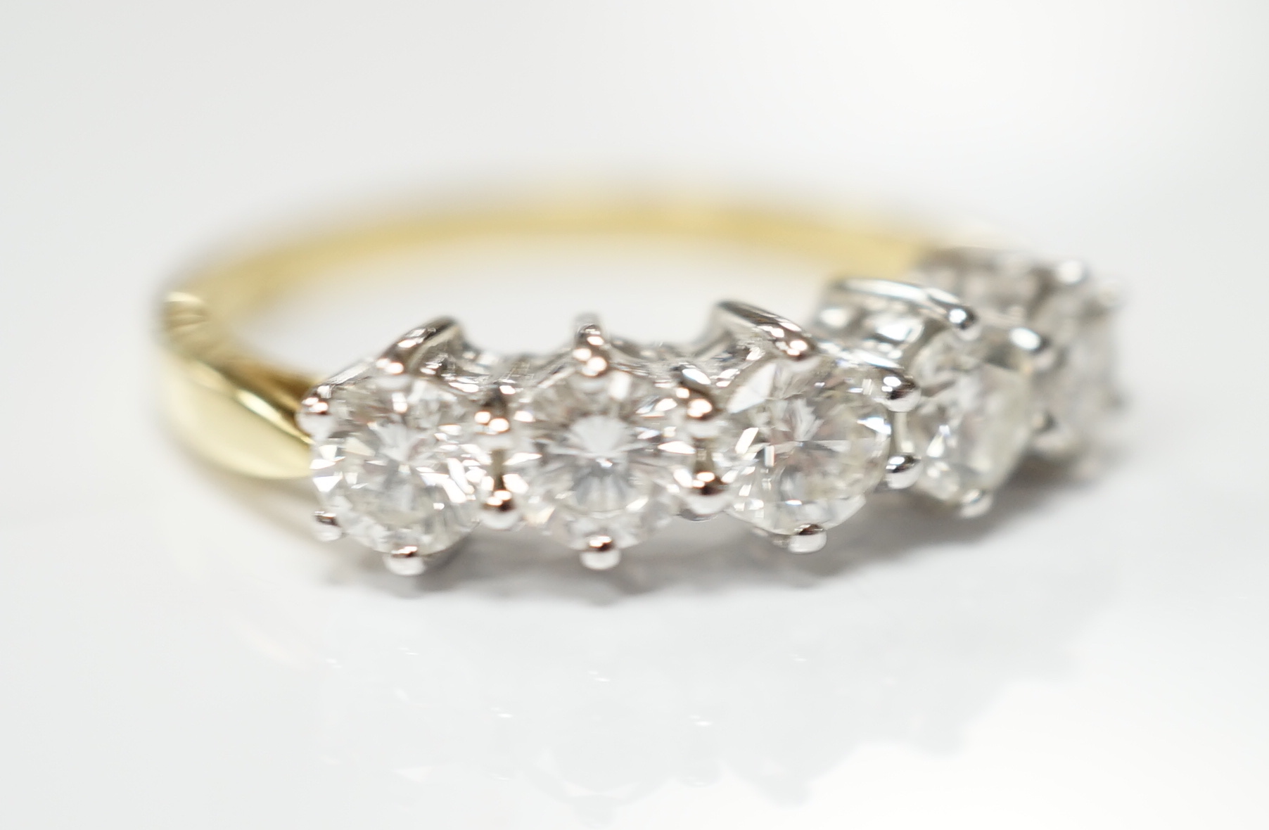 A modern 18ct gold and five stone diamond set half hoop ring, size N, gross weight 4 grams.